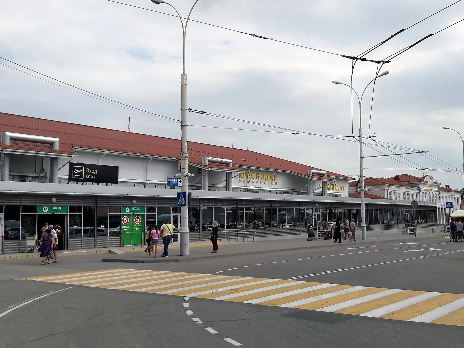 Вход в терминал аэропорта Краснодар и проезд перед ним с контактной сетью троллейбуса